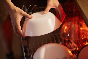 Clean plates after washing in the dishwasher. Close-up of the dishes placed in the dishwasher....