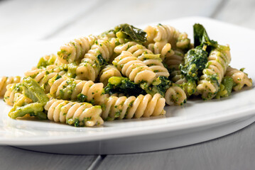 Piatto di deliziosi fusilli conditi con crema di broccoli, pasta italiana vegetariana 