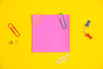 Bright pink sticker for notes and stationery buttons with paper clips yellow background.