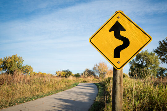 Naklejki sharp curve ahead or winding road - warning sign on a bike trail in northern Colorado
