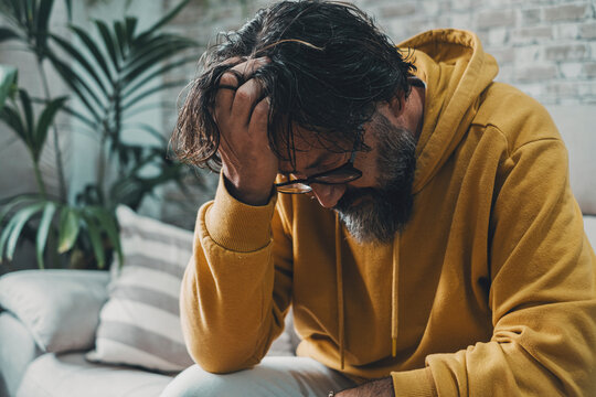 One desperate frustrated man alone at home holding his head on hand looking down. Stress and bad mental health condition concept. People and problems. psychologist. Home crisis image. Sadness bad day
