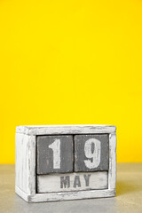 May 19 calendar made wooden cubes yellow background.With an empty space for your text.