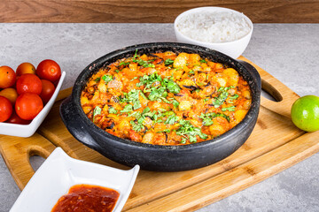 Charru Mussel, known in Brazil as Sururu Moqueca, on wooden board. Beside pepper, lemon, small tomatoes and rice