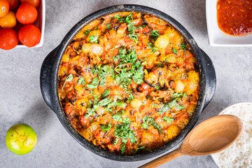 Charru Mussel, known in Brazil as a sururu moqueca, on white wooden table, next to lemon, small tomatoes, rice and pepper sauce, and a wooden spoon