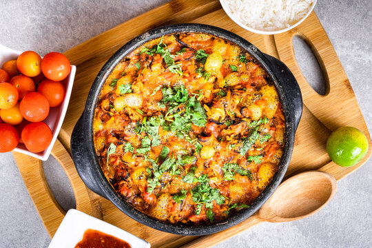 Charru Mussel, known in Brazil as Sururu Moqueca, on wooden board. Beside pepper, lemon, small tomatoes and rice