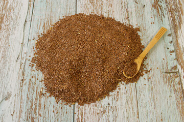 Flaxseed distributed on a wooden table, it is used for digestion and improves health