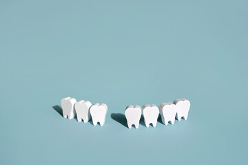 A model of teeth on a blue background with a missing front tooth . The problem of tooth loss. Daily care and oral hygiene