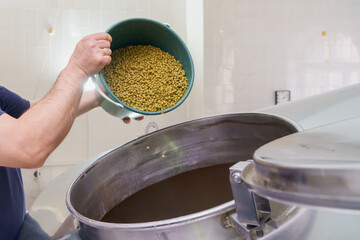 The process of adding malt to a vat at a brewery, motion blur, steam from brewing beer. Background
