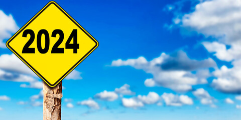 2024 new year concept ahead road sign with trunk tree, sky background