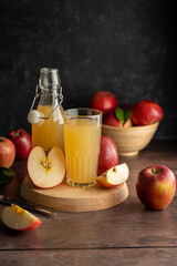 Apple juice drink with fresh red apples, wooden background. dark bakground