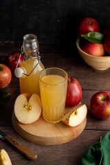 Apple juice drink with fresh red apples, wooden background. dark bakground