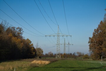 Electricity providing power lines making a cut though a forest