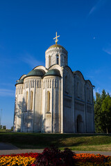 Fototapeta na wymiar VLADIMIR, Russia - AUGUST, 17, 2022: old white-stone Dmitrievsky Cathedral with a golden dome close-up on a sunny summer day