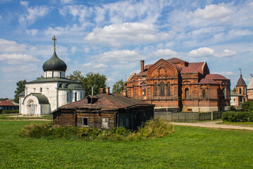 A beautiful urban landscape - the old town of Yuriev-polsky with ancient temples, a wooden hut and green trees on a sunny summer day and a space for copying