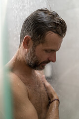 Middle-aged man in the shower, drops of water.