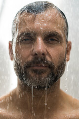 Fototapeta na wymiar Middle-aged man in the shower, drops of water.