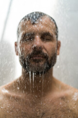 Fototapeta na wymiar Middle-aged man in the shower, drops of water.