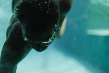 Man swimmer in the pool underwater.