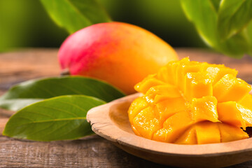 Mango fruit. Ripe Mango fruits on wooden table over nature background. Close-up of fresh juicy...