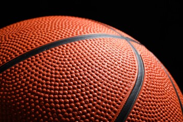 Fototapeta premium Orange basketball ball on black background, closeup