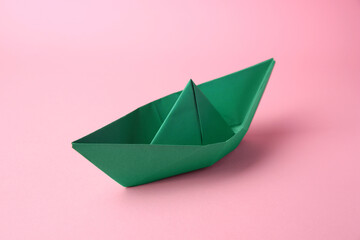 Origami art. Paper boat on pink background