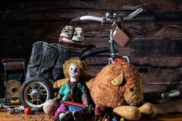 old toys in attic with dark wood background including tricycle stuffed lion and vintage camera