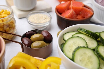 Ingredients for poke bowl on white checkered table, closeup