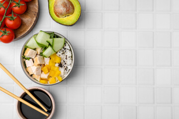 Delicious poke bowl with meat, rice and vegetables served on white table, flat lay. Space for text