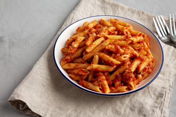 Homemade Penne With Tomato Sauce on a Plate, side view. Copy space.