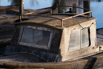 An old pleasure boat is moored on a narrow picturesque river, background