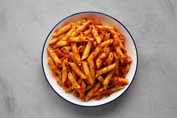 Homemade Penne With Tomato Sauce on a Plate, top view. From above, overhead, flat lay.
