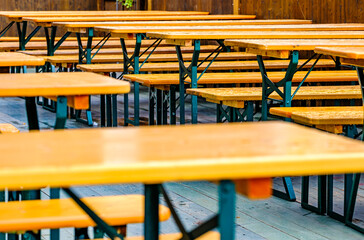 typical bavarian beergarden with wooden benches and tables