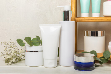 Skin care stage for healthy skin - face serum and lotion, scrub, peeling and cleanser on white wooden background. The concept of beauty and cosmetics. A set of cosmetics on a wooden shelf. 