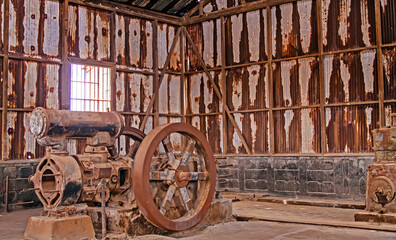 Abandoned old industrial machinery in rusty industrial hall, salpeter mining village closed 1960 -...