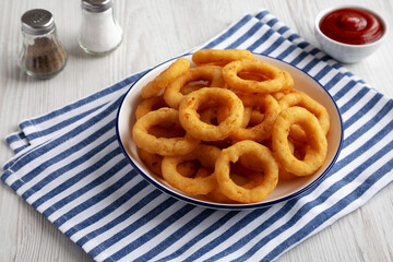 Homemade Breaded Onion Rings with Ketchup on a Plate, side view.