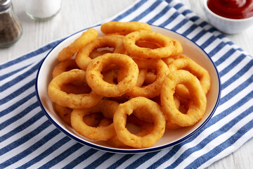 Homemade Breaded Onion Rings with Ketchup on a Plate, side view.