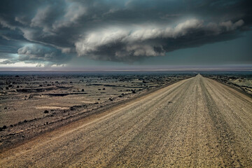 Endless gravel road in monotonous life hostile arid barren surreal gray stone and sand  atacama...