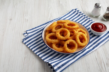 Homemade Breaded Onion Rings with Ketchup on a Plate, low angle view. Copy space.