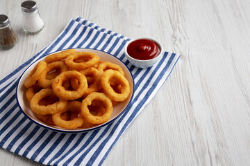 Homemade Breaded Onion Rings with Ketchup on a Plate, low angle view. Space for text.