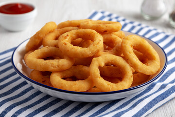 Homemade Breaded Onion Rings with Ketchup on a Plate, low angle view. Close-up.