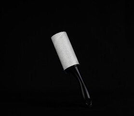 Roller for cleaning clothes from pet hair isolated on black background, close up