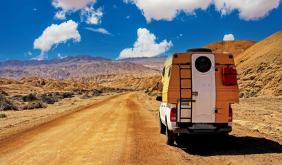Camper truck trip on red dirt track sand road, barren lonely wild desert valley - Chile, Atacama...