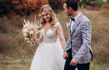Wedding couple with bouquet with roses and spikelets and pampas grass .Boho style wedding