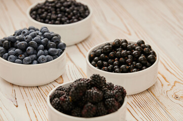 Fototapeta na wymiar Ripe blueberries, assortment of ripe berries in bowls