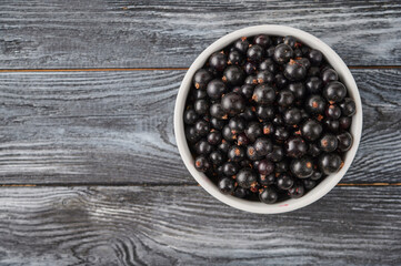 Fototapeta na wymiar Ripe black currant berries on a table in a plate