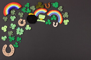 St Patrick's Day concept. Knitted composition of a green hat, a pot of gold, a horseshoe, a rainbow...