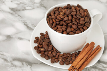 coffee beans in a white mug on a saucer