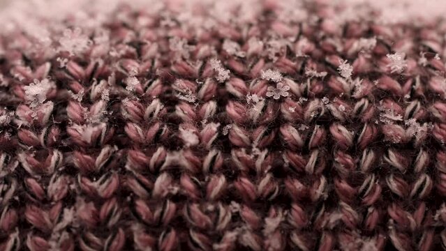 Macro footage of snowflakes falling onto a knitted hat in Ontario, Canada.