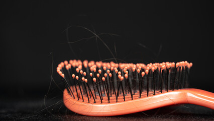 hair loss problem. Brush with hair on black background