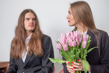 Elegant serious couple looking stright. Portrait of a man and a woman wearing black suits. White...
